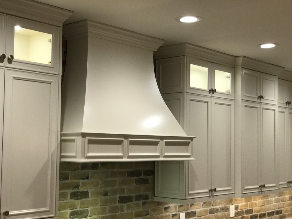 Inspiration for a mid-sized rustic single-wall dark wood floor and brown floor kitchen remodel in Atlanta with an undermount sink, beaded inset cabinets, white cabinets, granite countertops, multicolored backsplash, brick backsplash, white appliances, an island and gray countertops
