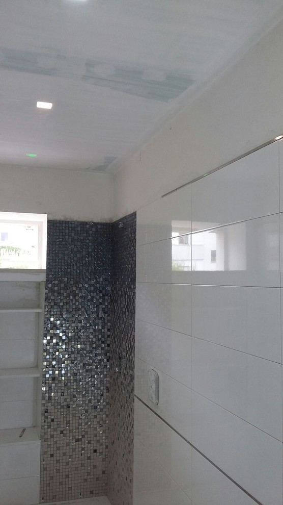 Mid-sized modern 3/4 bathroom in Other with furniture-like cabinets, an open shower, a two-piece toilet, white tile, mosaic tile, white walls, porcelain floors and a drop-in sink.