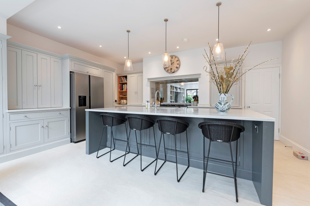 Design ideas for an expansive traditional l-shaped open plan kitchen in Dorset with a submerged sink, shaker cabinets, grey cabinets, quartz worktops, stainless steel appliances, an island and white worktops.