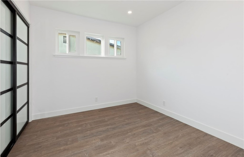 Idee per una camera degli ospiti minimal con pareti bianche, parquet chiaro e pavimento marrone