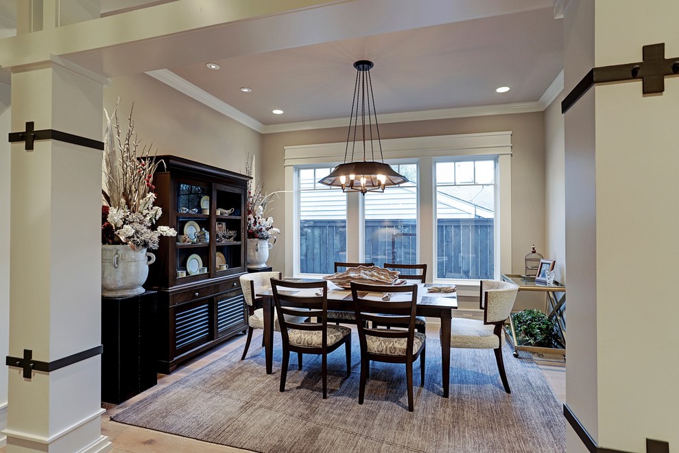 Inspiration for a mid-sized arts and crafts separate dining room in Houston with beige walls, light hardwood floors, no fireplace and brown floor.