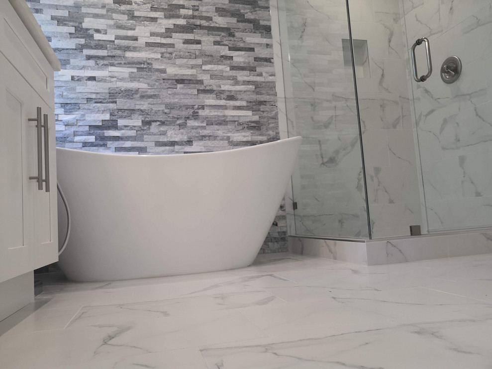 Mid-sized transitional master bathroom in Los Angeles with recessed-panel cabinets, white cabinets, a freestanding tub, a corner shower, a bidet, white tile, porcelain tile, white walls, porcelain floors, an undermount sink, engineered quartz benchtops, grey floor, a hinged shower door and white benchtops.