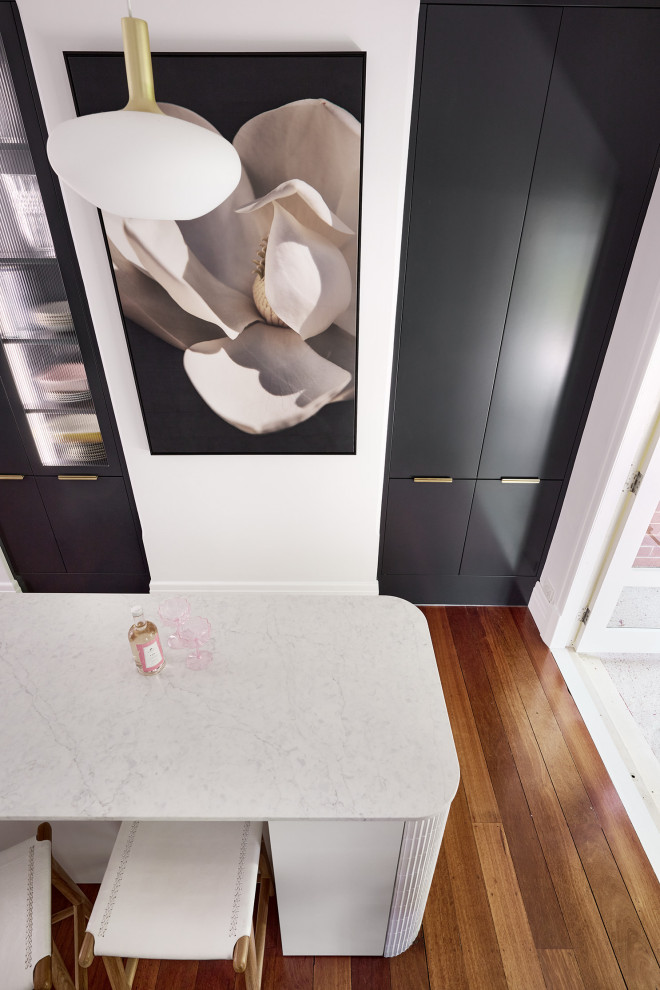 Kitchen - large modern galley dark wood floor and brown floor kitchen idea in Perth with an undermount sink, flat-panel cabinets, white cabinets, quartz countertops, white backsplash, quartz backsplash, black appliances, an island and white countertops