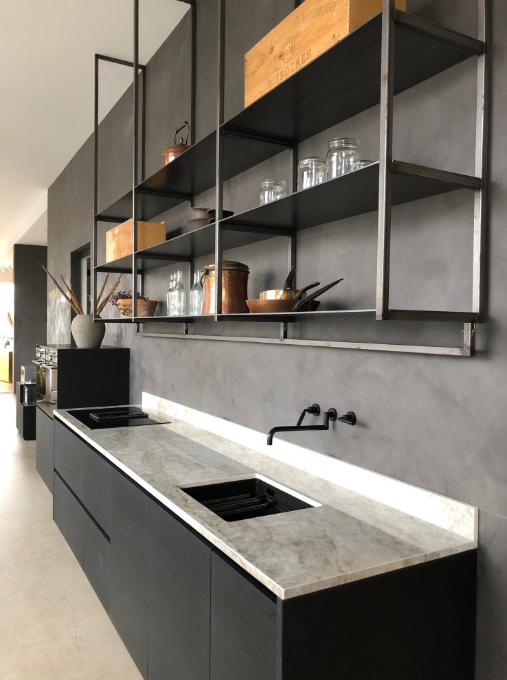 Mid-sized scandinavian single-wall eat-in kitchen in Malmo with a single-bowl sink, flat-panel cabinets, black cabinets, quartz benchtops, beige splashback, black appliances, concrete floors, no island, grey floor and beige benchtop.