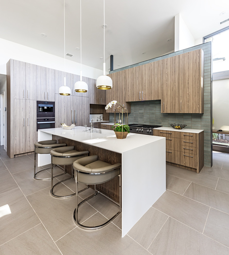 Photo of a mid-sized contemporary l-shaped open plan kitchen in Dallas with an undermount sink, flat-panel cabinets, medium wood cabinets, solid surface benchtops, ceramic splashback, porcelain floors, with island, grey splashback, panelled appliances and beige floor.