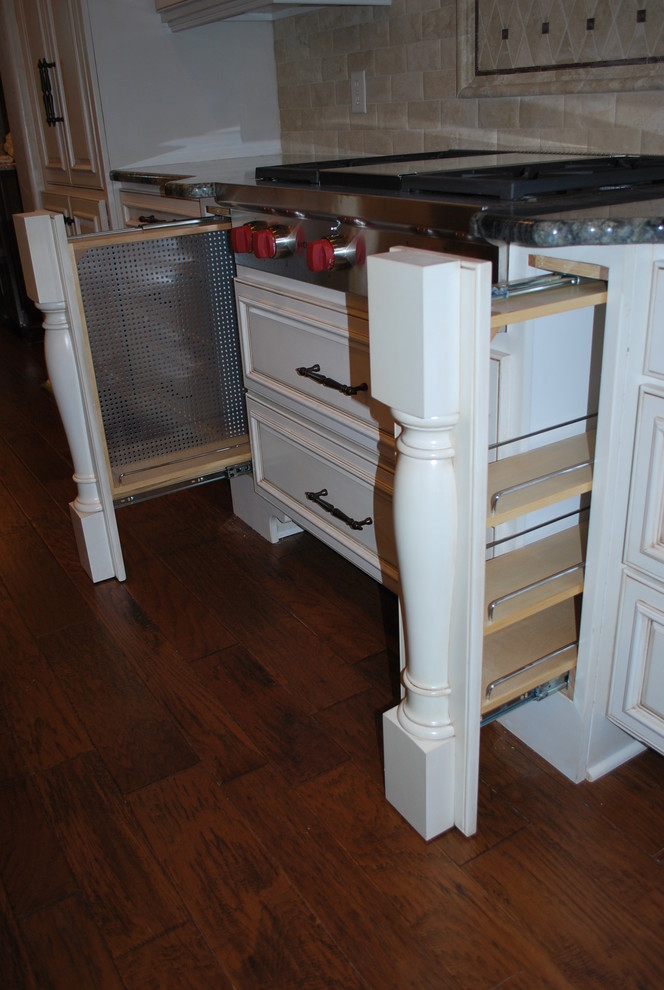 Eat-in kitchen - transitional u-shaped medium tone wood floor and brown floor eat-in kitchen idea with an undermount sink, white cabinets, granite countertops, travertine backsplash, paneled appliances and two islands