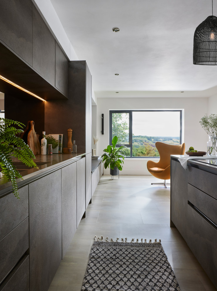 Inspiration for a mid-sized modern galley open plan kitchen in Other with a drop-in sink, flat-panel cabinets, solid surface benchtops, mirror splashback, panelled appliances, vinyl floors, with island, grey floor and beige benchtop.