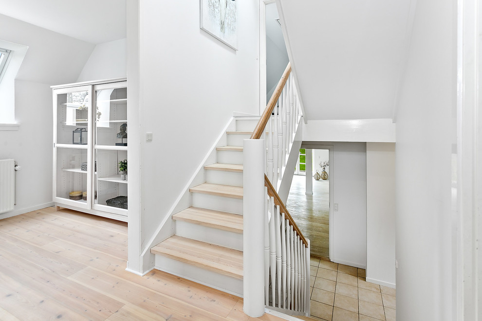 Scandinavian wood straight staircase in Copenhagen with wood risers and wood railing.