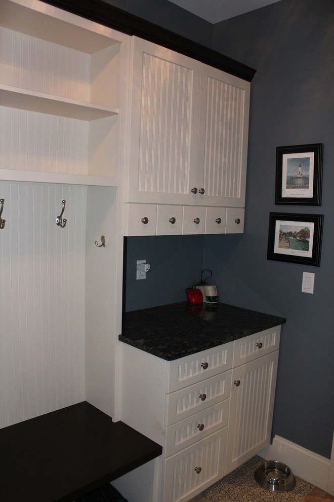 Inspiration for a large transitional travertine floor mudroom remodel with blue walls