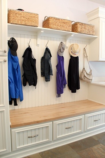 This is an example of a mid-sized traditional single-wall utility room in Other with a farmhouse sink, recessed-panel cabinets, white cabinets, wood benchtops, purple walls, porcelain floors, a side-by-side washer and dryer and grey floor.