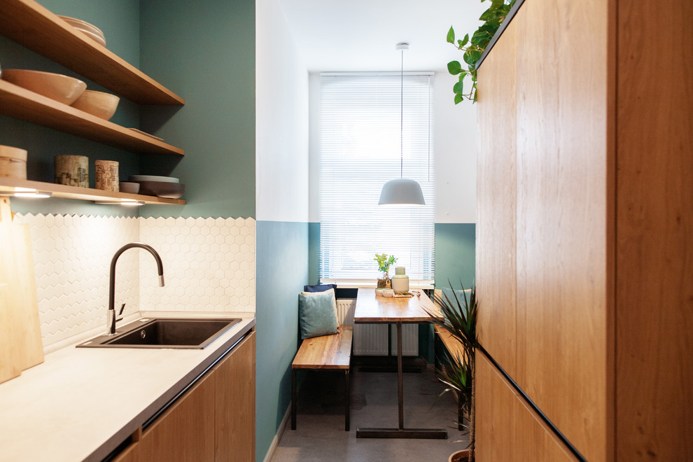 Small contemporary single-wall separate kitchen in Berlin with a drop-in sink, flat-panel cabinets, medium wood cabinets, white splashback, ceramic splashback, no island, grey floor and white benchtop.