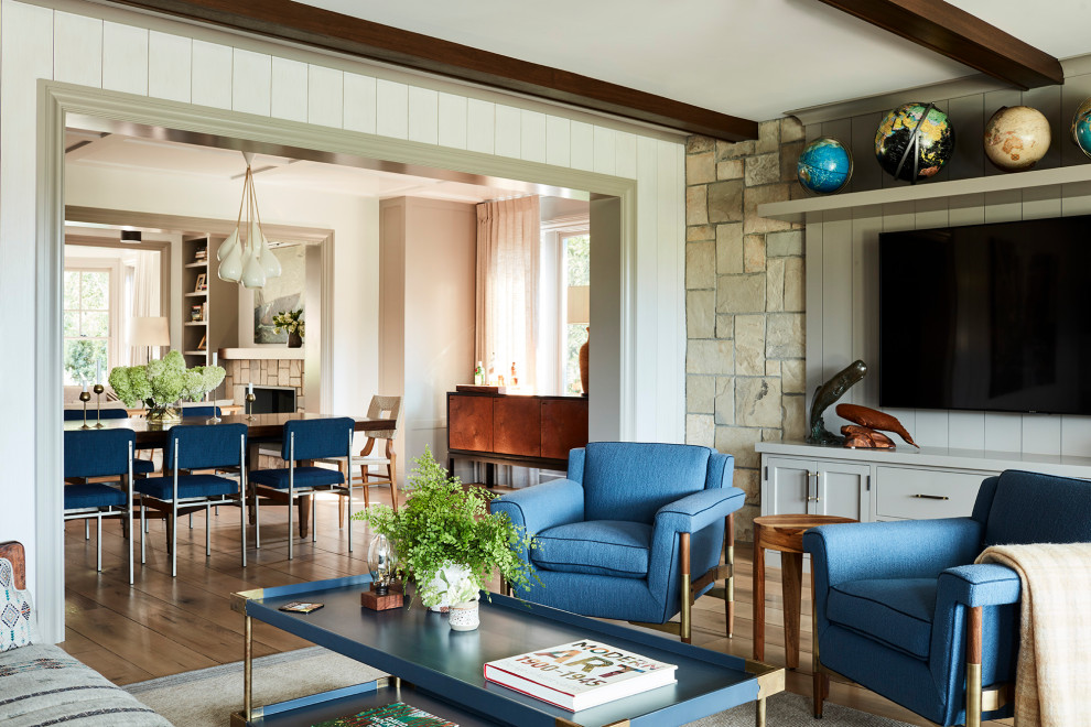 Diseño de sala de estar abierta rural con suelo de madera en tonos medios, televisor colgado en la pared, suelo marrón y vigas vistas
