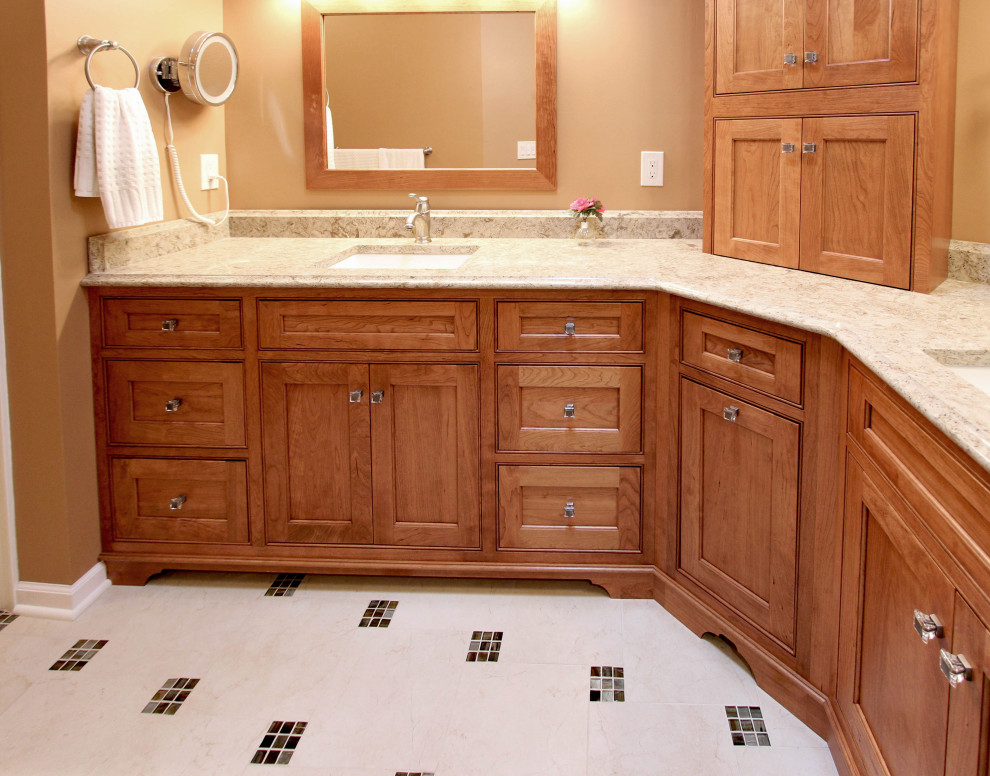 This is an example of a mid-sized traditional master bathroom in Cleveland with raised-panel cabinets, medium wood cabinets, an alcove shower, a two-piece toilet, beige tile, ceramic tile, orange walls, porcelain floors, an undermount sink, engineered quartz benchtops, beige floor, a hinged shower door and beige benchtops.