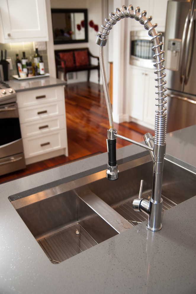 Eat-in kitchen - small transitional u-shaped dark wood floor eat-in kitchen idea with an undermount sink, shaker cabinets, white cabinets, quartzite countertops, gray backsplash, glass tile backsplash, stainless steel appliances and a peninsula