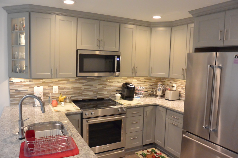 Example of a small transitional u-shaped vinyl floor and brown floor eat-in kitchen design in DC Metro with an undermount sink, shaker cabinets, gray cabinets, granite countertops, gray backsplash, mosaic tile backsplash, stainless steel appliances, a peninsula and gray countertops