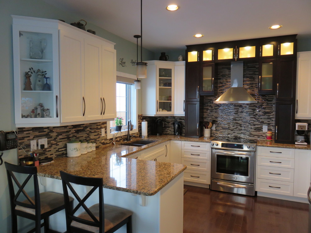 Mid-sized transitional u-shaped dark wood floor and brown floor eat-in kitchen photo with white cabinets, quartz countertops, stainless steel appliances, a peninsula, matchstick tile backsplash, a double-bowl sink, shaker cabinets and brown backsplash