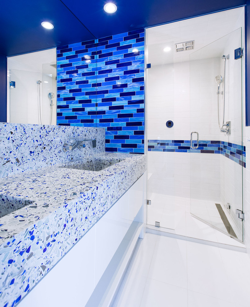This is an example of a mid-sized contemporary 3/4 bathroom in Denver with an alcove shower, blue tile, white tile, subway tile, blue walls, an integrated sink, flat-panel cabinets, white cabinets, porcelain floors, terrazzo benchtops, white floor, a hinged shower door and multi-coloured benchtops.
