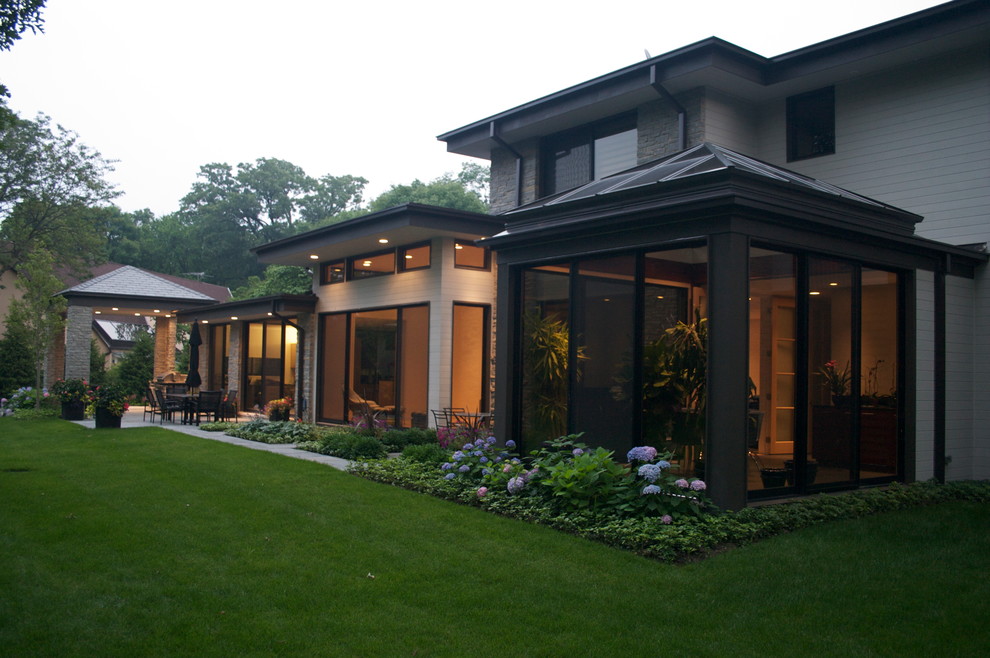 Photo of a large contemporary two-storey beige exterior in Chicago with mixed siding and a hip roof.