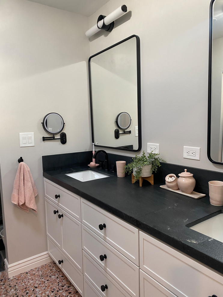 Photo of a medium sized midcentury bathroom in Phoenix with white cabinets, terrazzo flooring, a submerged sink, granite worktops, pink floors, black worktops and double sinks.