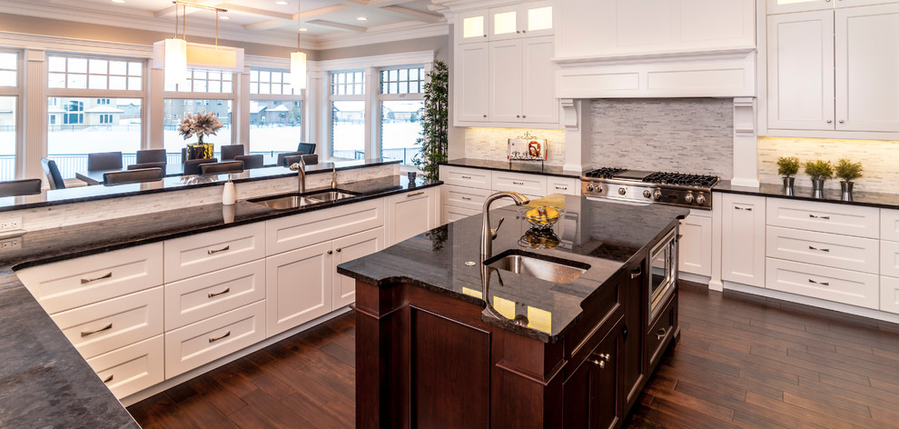 Inspiration for a large traditional u-shaped open plan kitchen in Edmonton with a single-bowl sink, shaker cabinets, white cabinets, granite benchtops, stainless steel appliances, dark hardwood floors and with island.