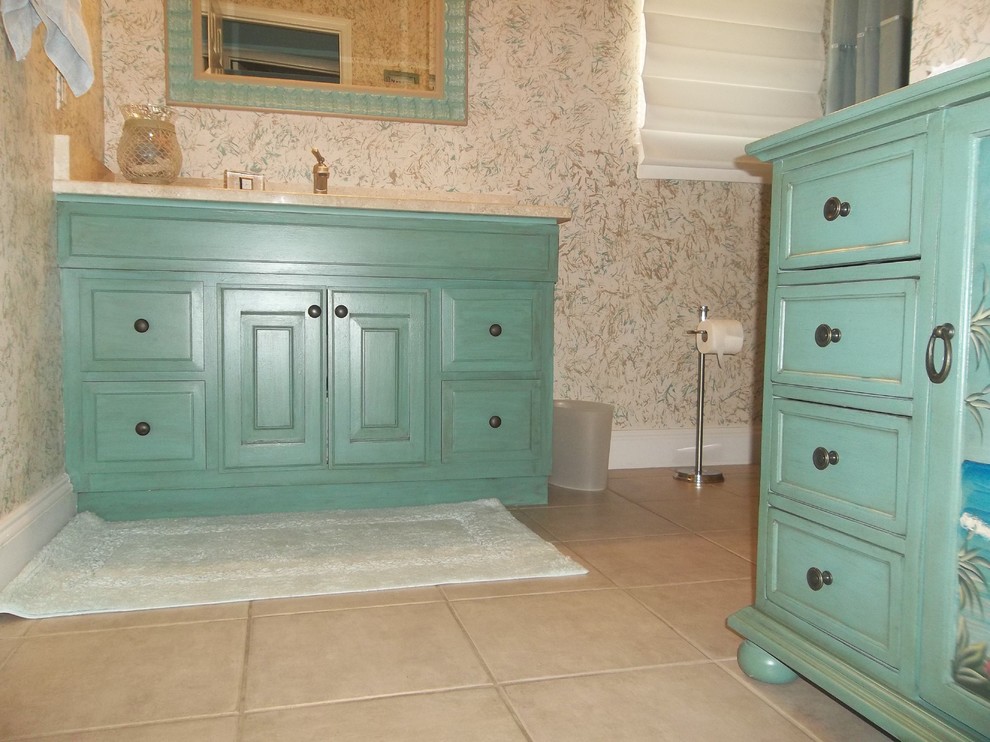 This is an example of a mid-sized tropical 3/4 bathroom in Tampa with furniture-like cabinets, turquoise cabinets, multi-coloured walls, ceramic floors, soapstone benchtops and beige floor.
