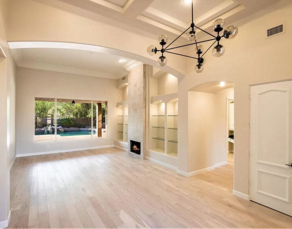 Example of a small open concept light wood floor and white floor living room design in Phoenix with beige walls, a standard fireplace and a tile fireplace