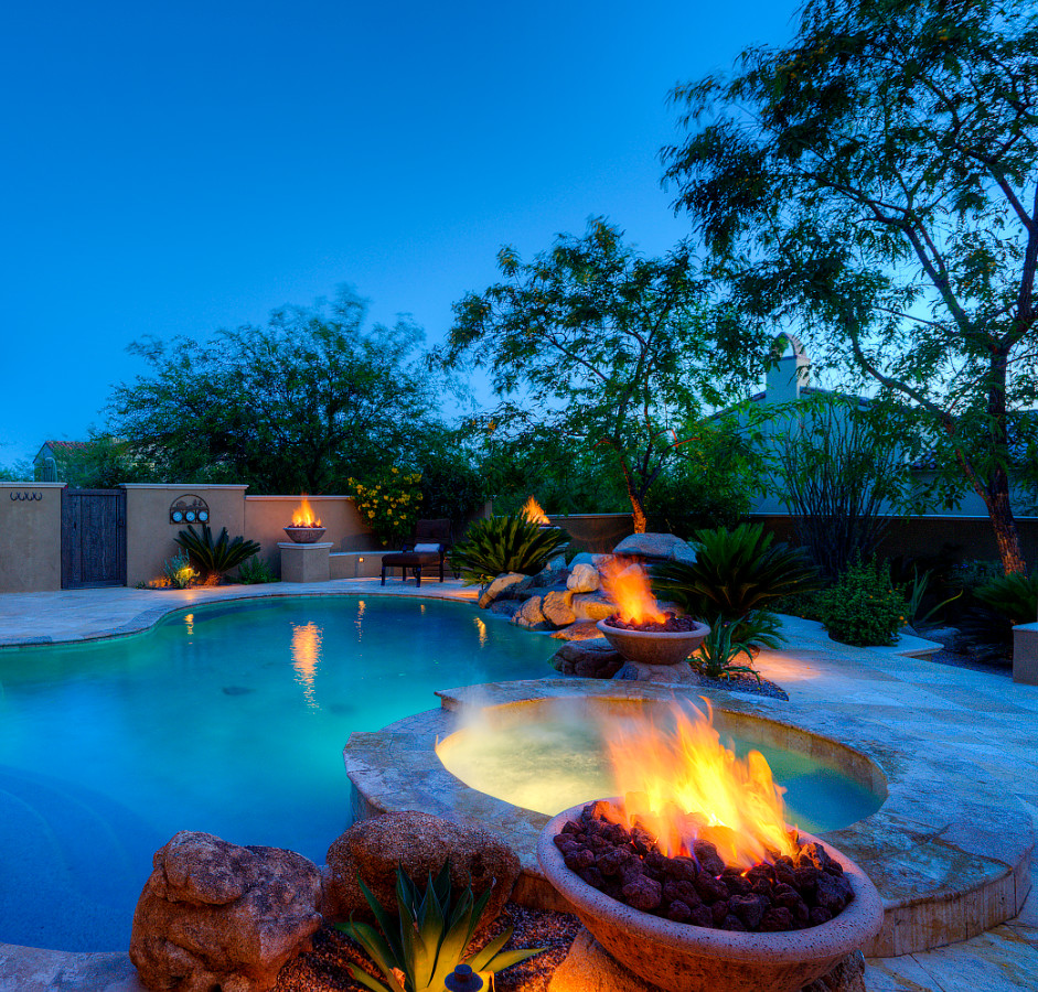 Photo of a large mediterranean backyard garden for spring in Phoenix with a fire feature and natural stone pavers.
