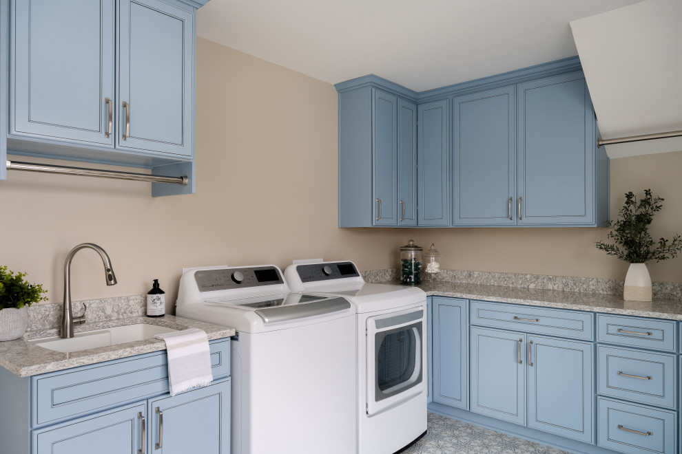 Inspiration för mellanstora moderna parallella tvättstugor enbart för tvätt, med en undermonterad diskho, blå skåp, granitbänkskiva, beige väggar, klinkergolv i keramik och en tvättmaskin och torktumlare bredvid varandra