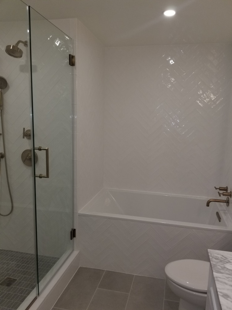 На фото: ванная комната среднего размера в стиле модернизм с накладной ванной, душем над ванной, керамической плиткой, полом из керамической плитки, серым полом и душем с распашными дверями