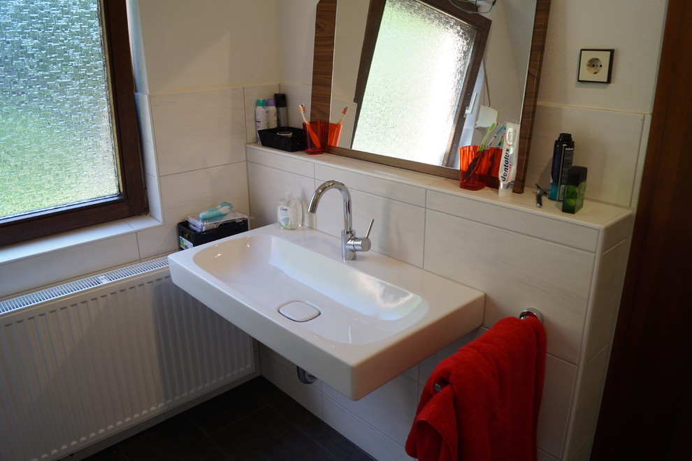 Photo of a large contemporary master bathroom in Stuttgart with a drop-in tub, a corner shower, a two-piece toilet, white tile, ceramic tile, white walls, ceramic floors and a trough sink.