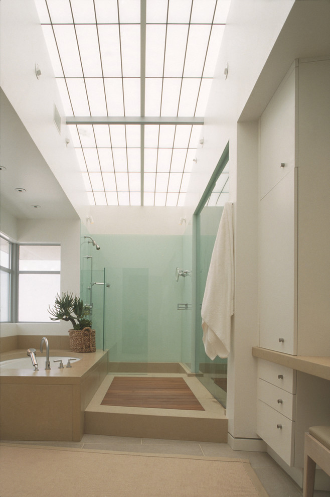 Modern bathroom in Los Angeles with flat-panel cabinets, white cabinets, an undermount tub and an alcove shower.