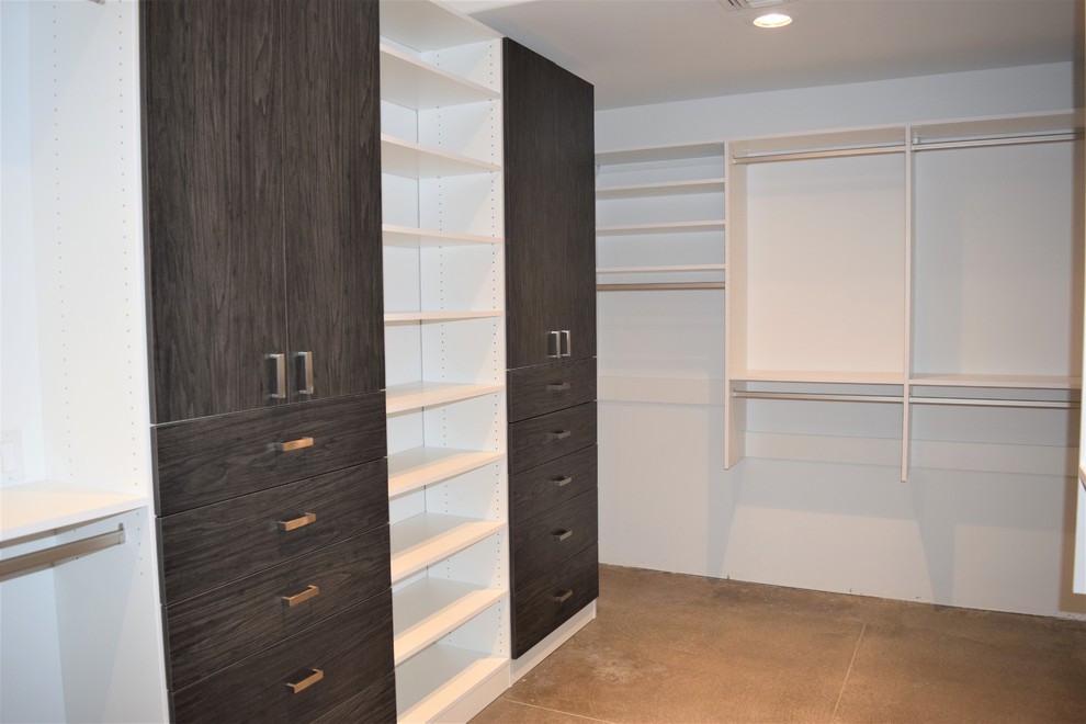 Design ideas for a contemporary storage and wardrobe in Phoenix with flat-panel cabinets, dark wood cabinets, concrete floors and grey floor.