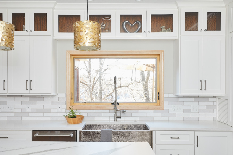 Design ideas for a large contemporary u-shaped eat-in kitchen in Minneapolis with a farmhouse sink, shaker cabinets, white cabinets, quartz benchtops, grey splashback, subway tile splashback, stainless steel appliances, ceramic floors, with island, grey floor and white benchtop.
