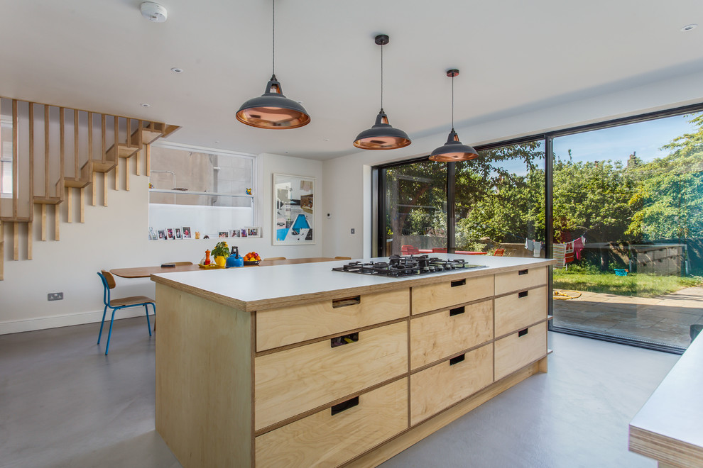 Large eclectic open plan kitchen in Sussex with a double-bowl sink, open cabinets, light wood cabinets, laminate benchtops, beige splashback, timber splashback, black appliances, concrete floors, with island, grey floor and white benchtop.