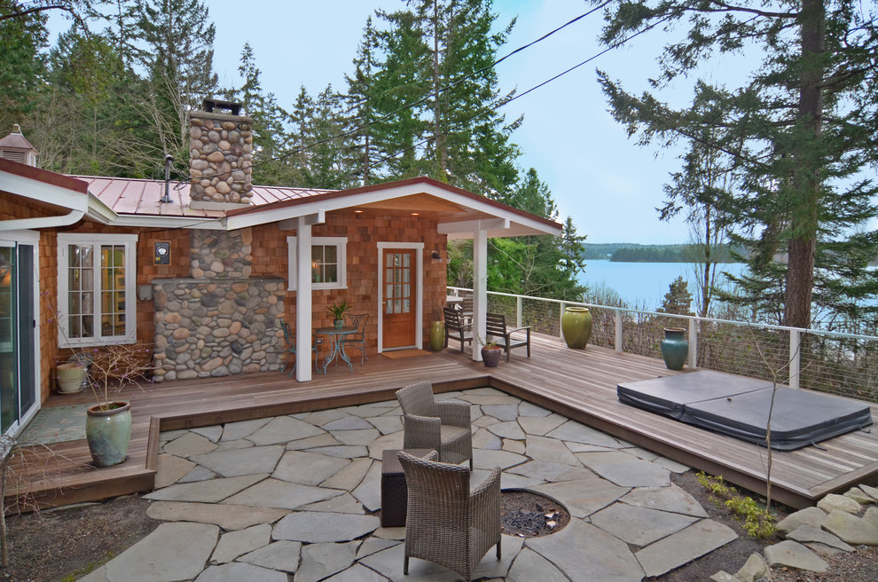 Design ideas for a mid-sized country patio in Seattle with a fire feature, natural stone pavers and no cover.