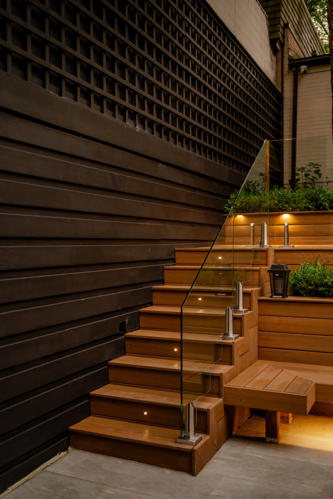 На фото: маленькая прямая деревянная лестница в современном стиле с деревянными ступенями, стеклянными перилами и деревянными стенами для на участке и в саду