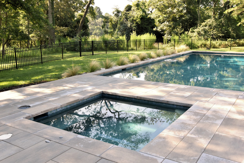 Inspiration for a large modern backyard rectangular pool in Other with concrete pavers.
