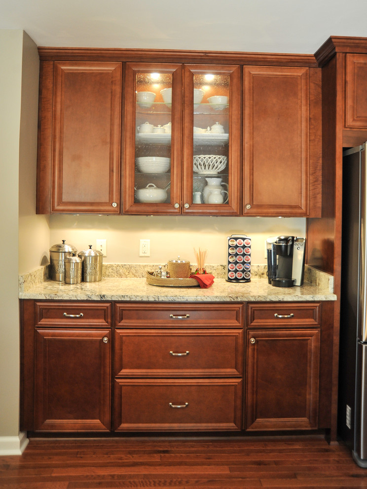 Eat-in kitchen - mid-sized transitional u-shaped medium tone wood floor eat-in kitchen idea in Birmingham with a double-bowl sink, flat-panel cabinets, medium tone wood cabinets, granite countertops, beige backsplash, stone tile backsplash, stainless steel appliances and a peninsula