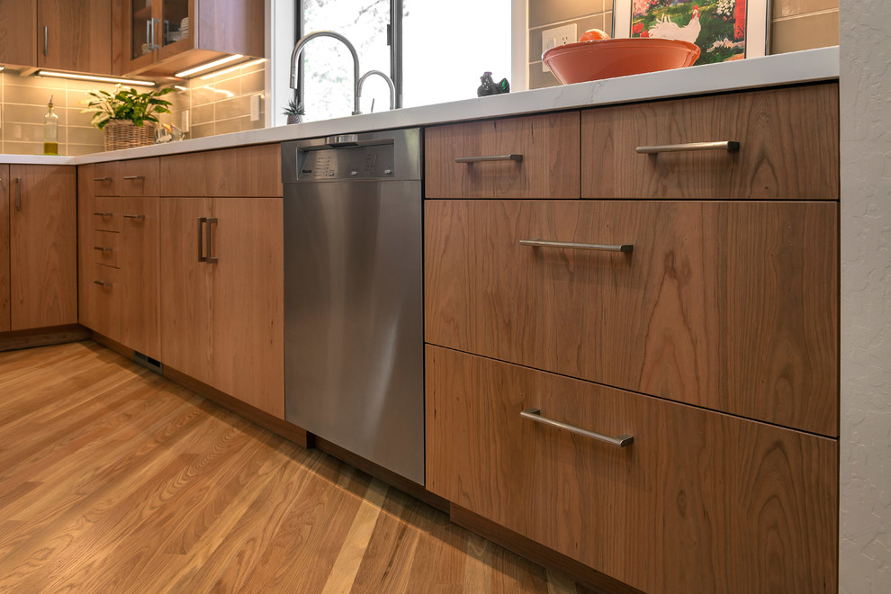Photo of a mid-sized modern galley separate kitchen in San Francisco with an undermount sink, flat-panel cabinets, medium wood cabinets, quartz benchtops, stainless steel appliances, with island and white benchtop.