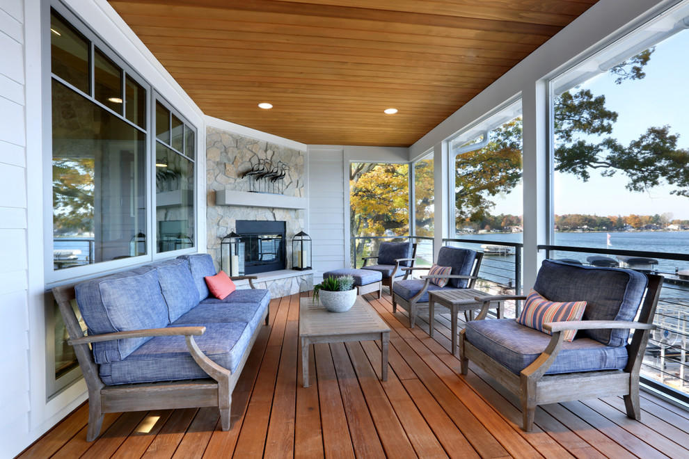 Inspiration for an expansive beach style backyard screened-in verandah in Grand Rapids with decking.