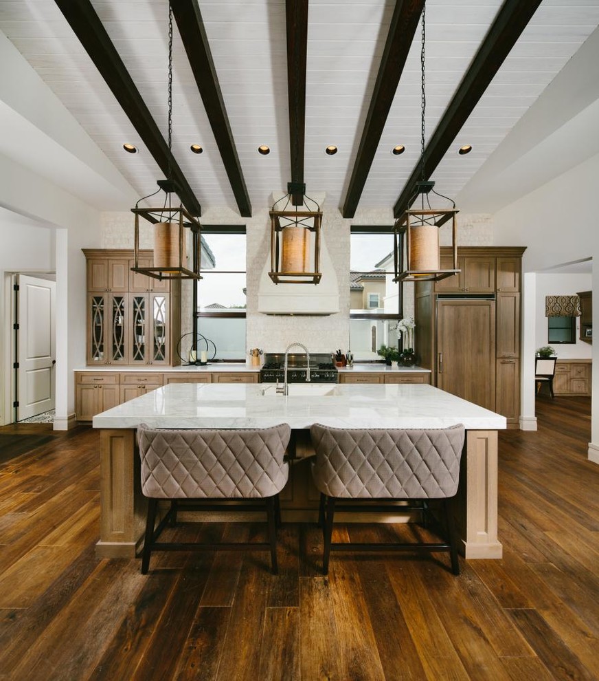 Traditional galley eat-in kitchen in Austin with recessed-panel cabinets, light wood cabinets, marble benchtops, white splashback, stone tile splashback, panelled appliances, medium hardwood floors and with island.