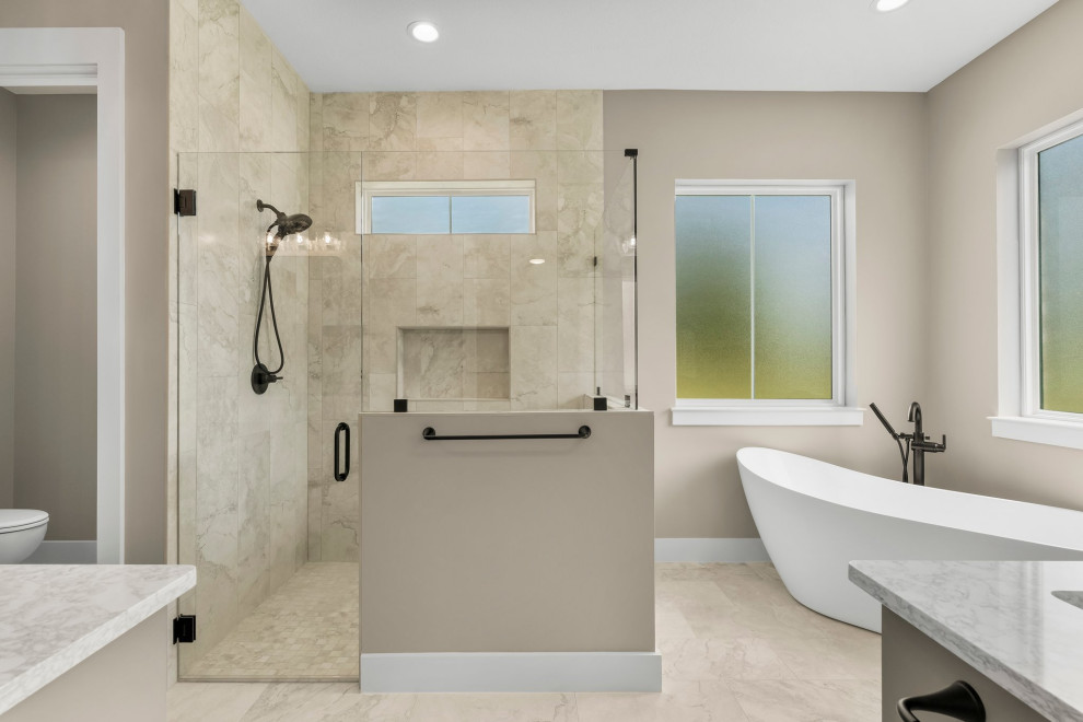 Freestanding bathtub - mid-sized craftsman master beige tile and porcelain tile porcelain tile, beige floor and double-sink freestanding bathtub idea with shaker cabinets, beige cabinets, a two-piece toilet, beige walls, an undermount sink, quartzite countertops, a hinged shower door, beige countertops and a built-in vanity