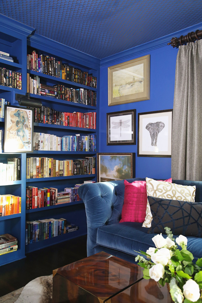 This is an example of a mid-sized traditional home office in Other with a library, blue walls, medium hardwood floors, a standard fireplace, a brick fireplace surround, a freestanding desk and brown floor.