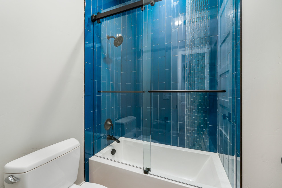 Стильный дизайн: большая детская ванная комната в стиле модернизм с фасадами в стиле шейкер, белыми фасадами, накладной ванной, открытым душем, раздельным унитазом, синей плиткой, стеклянной плиткой, серыми стенами, полом из керамогранита, врезной раковиной, столешницей из искусственного кварца, коричневым полом, душем с распашными дверями, белой столешницей, тумбой под две раковины и встроенной тумбой - последний тренд