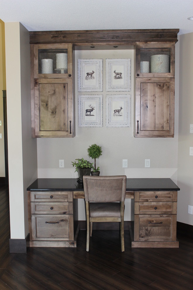 Design ideas for a mid-sized country home office in Other with beige walls, dark hardwood floors and a built-in desk.