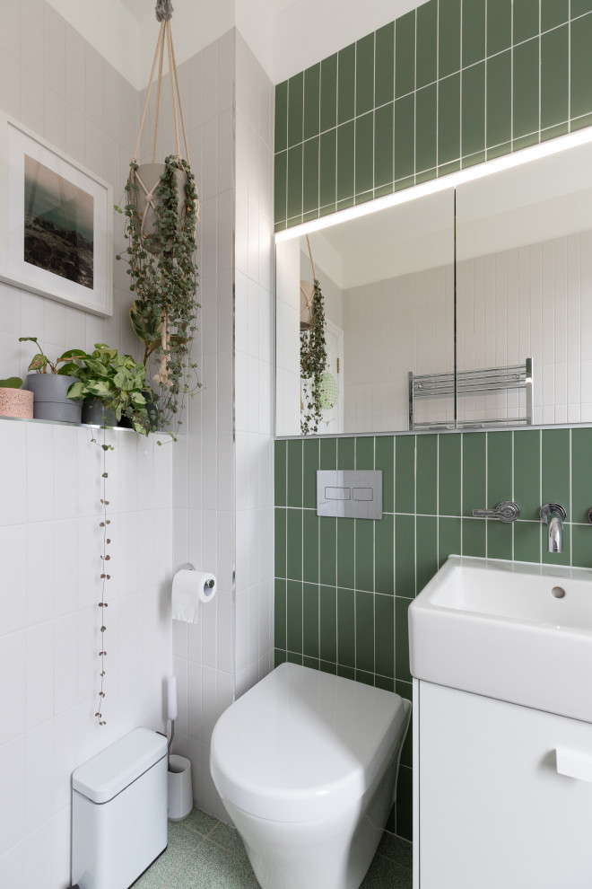 This is an example of a medium sized contemporary family bathroom in London with white cabinets, green tiles, ceramic tiles, ceramic flooring, green floors and a single sink.