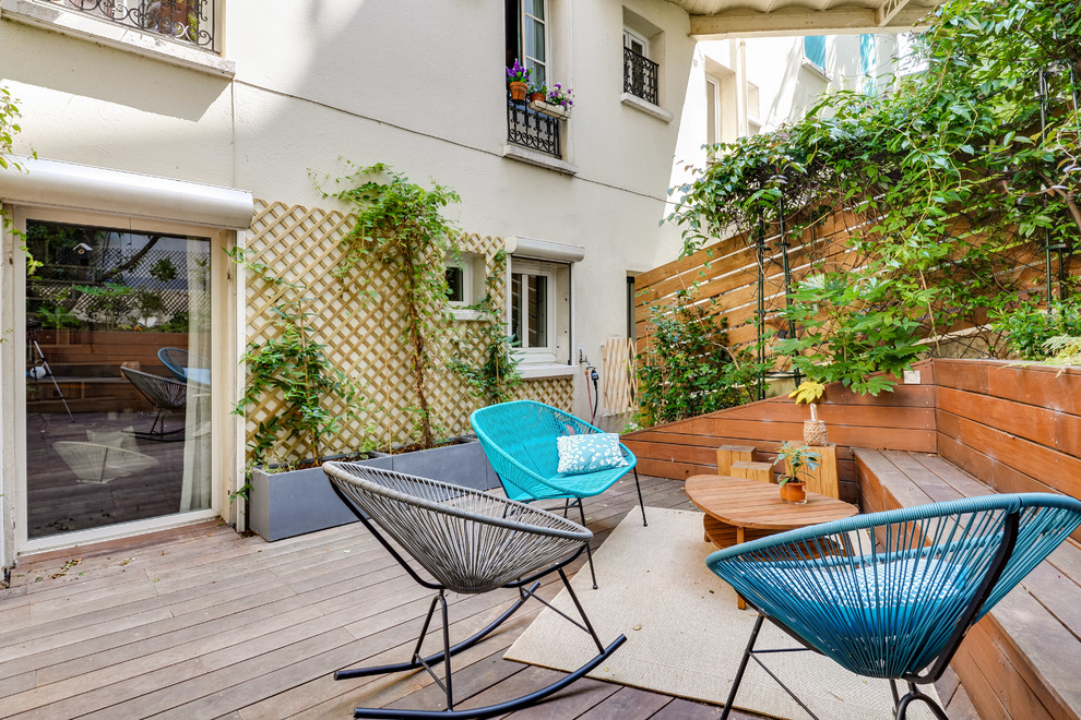 Mid-sized scandinavian backyard and ground level deck in Paris with a container garden, no cover and wood railing.