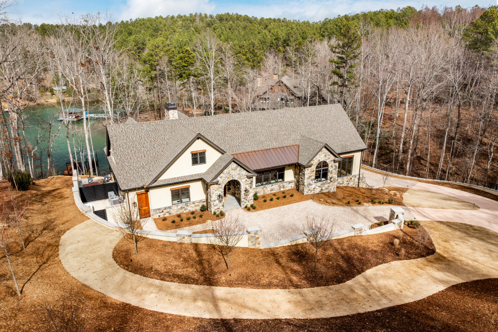 Example of a large transitional two-story stone gable roof design with a mixed material roof and a gray roof