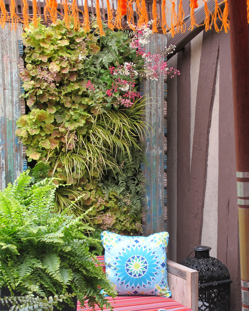 This is an example of a small eclectic patio in New York with a vertical garden, decking and no cover.
