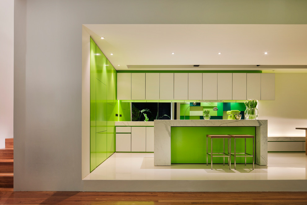 This is an example of a mid-sized contemporary l-shaped open plan kitchen in Melbourne with flat-panel cabinets, white cabinets, glass sheet splashback, panelled appliances and with island.
